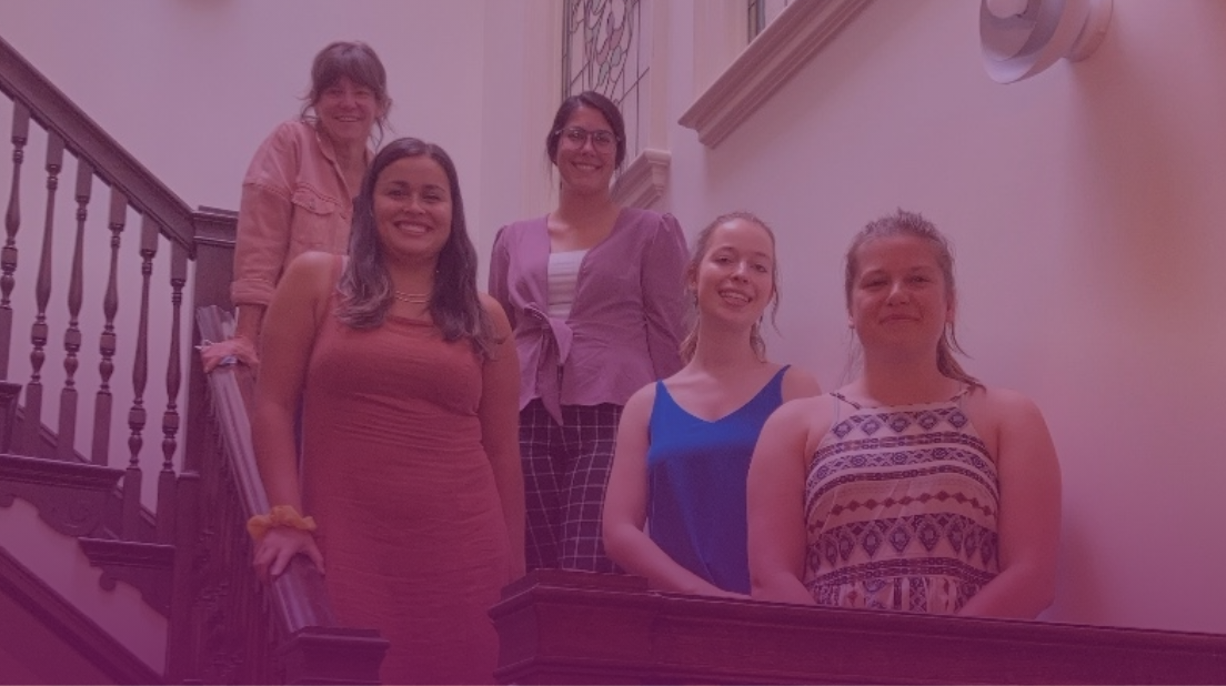 Photo of employees on the steps of a wooden staircase