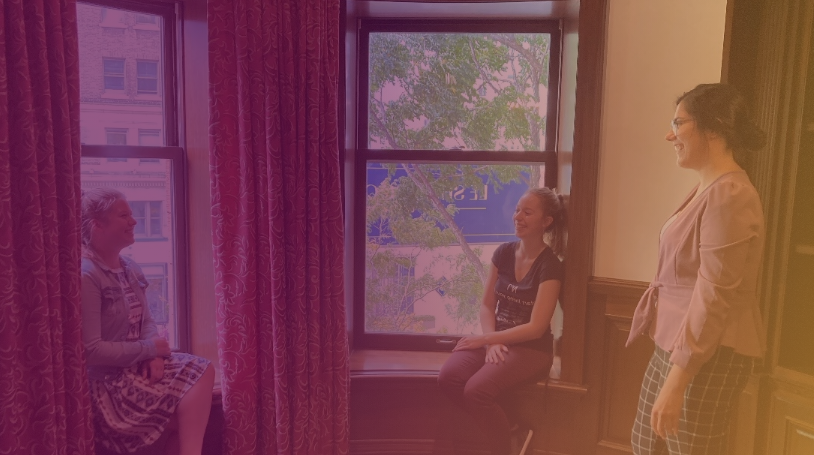 Photo of colleagues standing next to a window, and the words “People focus”